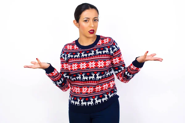 Young Beautiful Arab Woman Wearing Christmas Sweater Looks Uncertain Shrugs — Stock Photo, Image