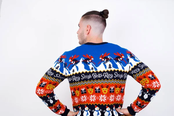 白い壁のスタジオの撮影に対するクリスマスのセーターを身に着けている白人男性の背面の景色 — ストック写真