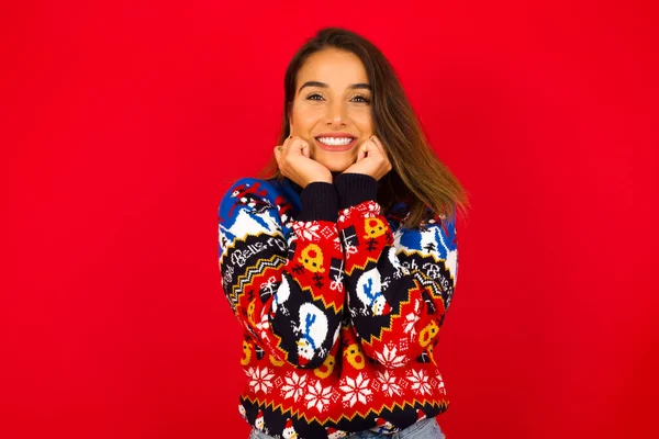 Verträumte Junge Schöne Kaukasische Frau Trägt Weihnachtspullover Gegen Rote Wand — Stockfoto