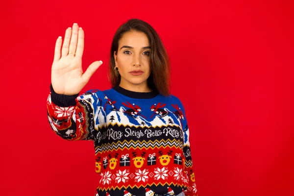 woman doing stop gesture with palm of the hand. Warning expression with negative and serious gesture on the face.