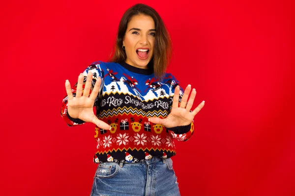 Dissatisfied Caucasian Woman Wearing Christmas Sweater Red Wall Frowns Face — Stock Photo, Image