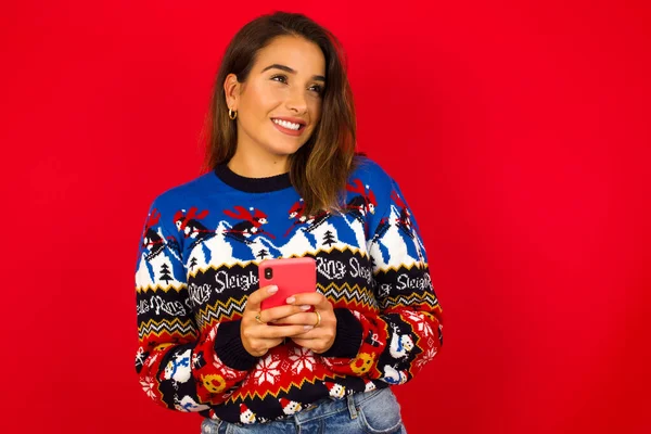 Glad Ung Vacker Vit Kvinna Bär Jultröja Mot Röd Vägg — Stockfoto