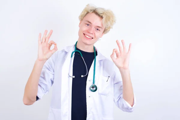 Feliz Jovem Bonito Médico Caucasiano Vestindo Casaco Branco Mostra Sinal — Fotografia de Stock