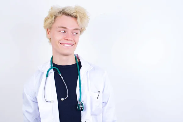 Νεαρός Όμορφος Καυκάσιος Γιατρός Φορώντας Λευκό Παλτό Στοχαστική Έκφραση Κοιτάζει — Φωτογραφία Αρχείου