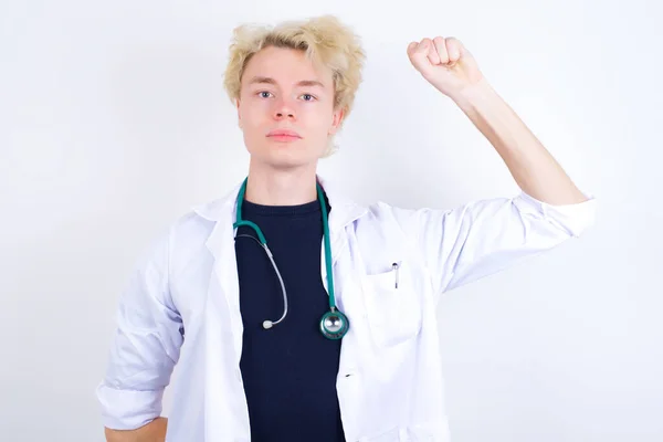 Νεαρός Όμορφος Καυκάσιος Γιατρός Φορώντας Λευκό Παλτό Αισθάνεται Σοβαρή Ισχυρή — Φωτογραφία Αρχείου