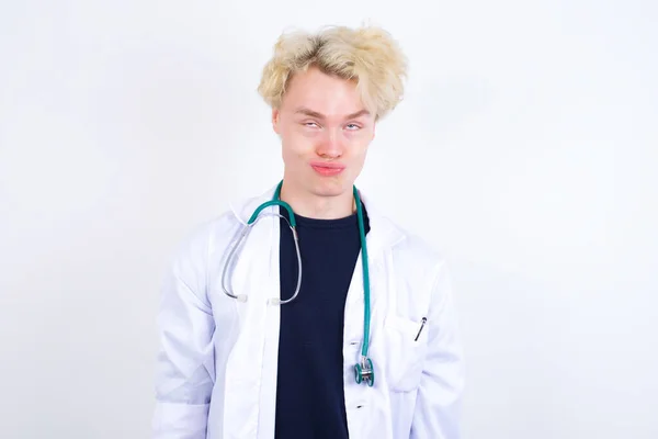 Young Handsome Caucasian Doctor Wearing White Coat Crosses Eyes Puts — Stock Photo, Image