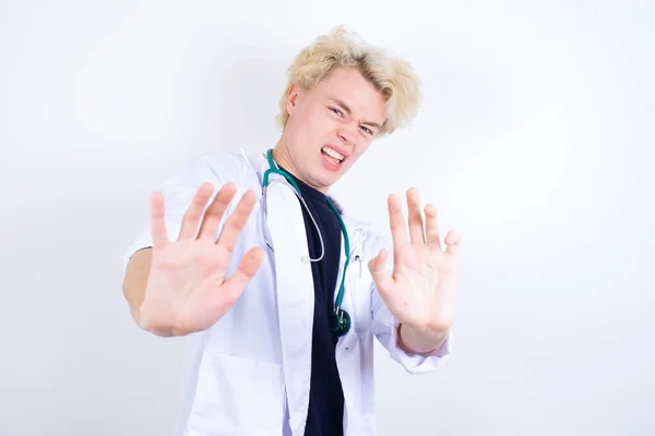 Dissatisfied Young Handsome Caucasian Doctor Wearing White Coat Frowns Face — Stock Photo, Image