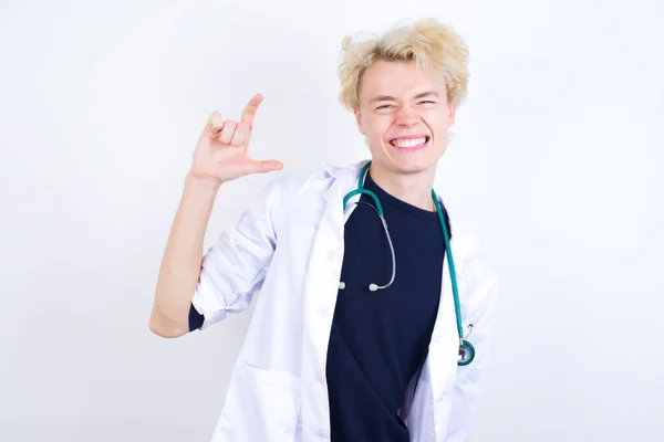 Jovem Bonito Médico Caucasiano Vestindo Casaco Branco Sorrindo Gesticulando Com — Fotografia de Stock