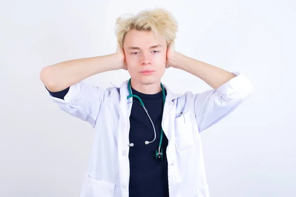 Frustrated Young Handsome Caucasian Doctor Wearing White Coat Plugging Ears — Stock Photo, Image