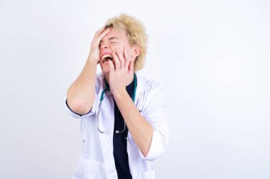 Genç, kasvetli doktor, elleri somurtkan, ağlayan, üzgün ve depresif bir şekilde iş sorunundan yakınan..