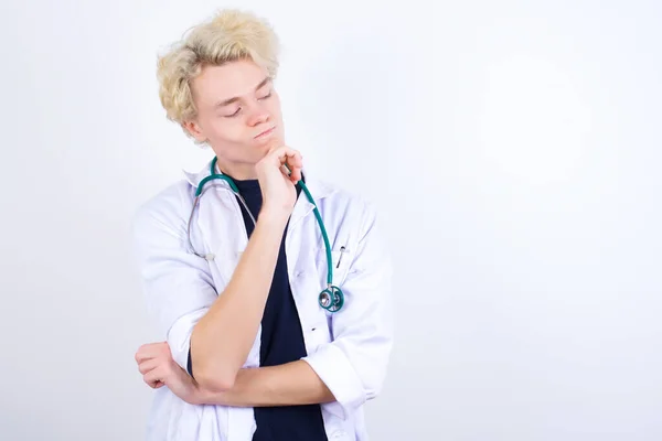 Médico Com Mão Sob Queixo Olhando Para Lados Com Expressão — Fotografia de Stock