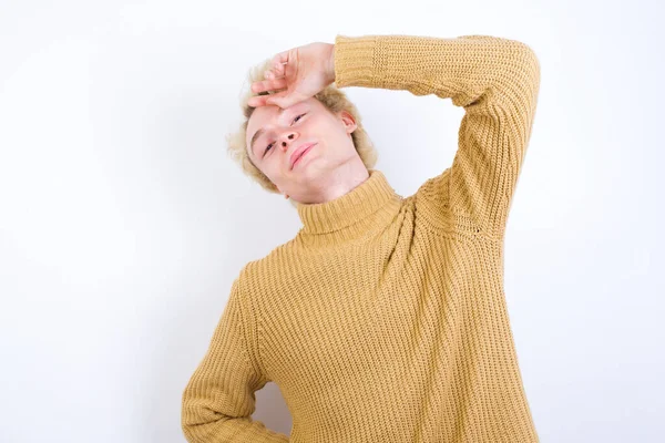 Knappe Blanke Blonde Man Staat Tegen Een Witte Achtergrond Vegen — Stockfoto