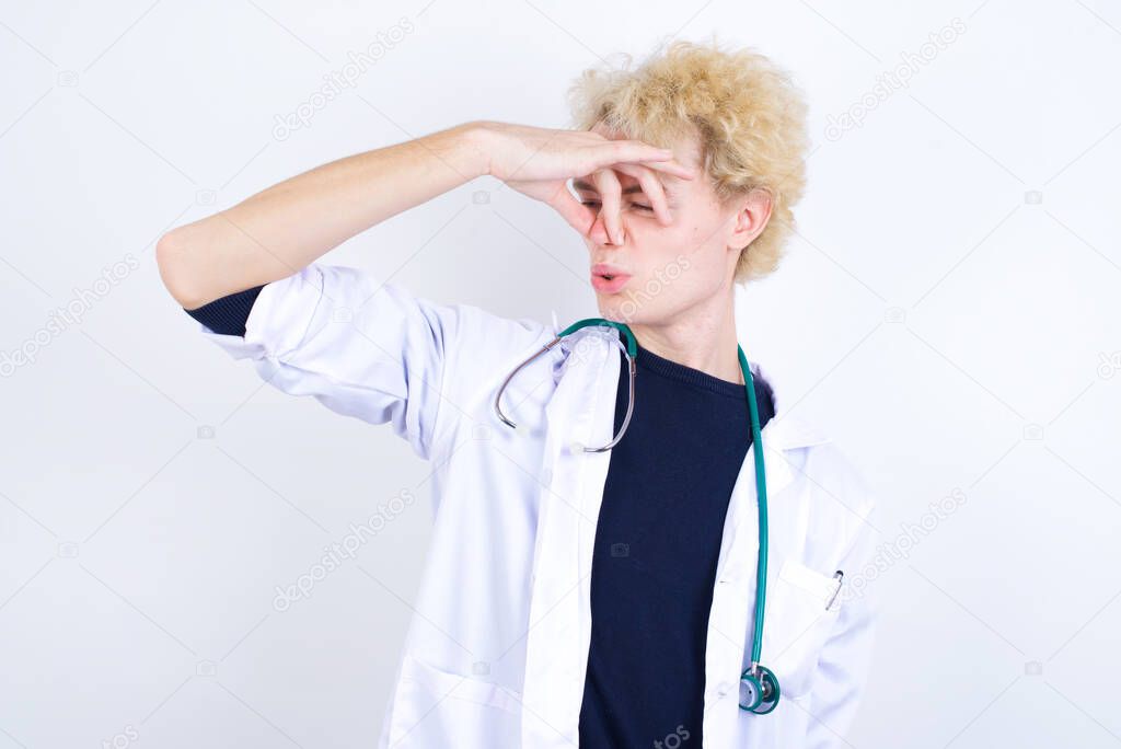 Displeased doctor   plugs nose as smells something stink and unpleasant, feels aversion, hates disgusting scent.