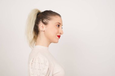 Sağlıklı ve saf cilde sahip gülümseyen bir kadının profili derin bir ifadeye sahiptir. Açık havada yürümeye hazırdır.