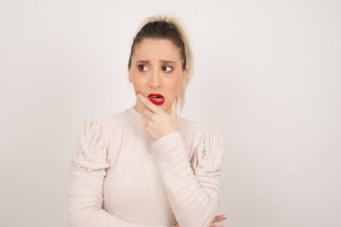 Endişe. Güzel bir genç kadının kavramsal görüntüsü. Ağzını elleriyle kapatıyor ve içeride duruyor. Bir şeyden ya da birinin çivi yemesinden korktun mu?