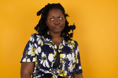 Hüzünlü, gündelik giysiler içinde, dudaklarıyla yukarıya bakan, önemli bir şey hakkında düşünmekten rahatsız olan genç Afrikalı Amerikalı kadın ellerini kaldırmıyor..