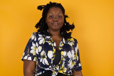 Güzel, Afro-Amerikalı bir kadının, hoş bir gülümseme ile kameraya bakarken boş fotokopi duvarına poz verirken ki görüntülerini kapatın.