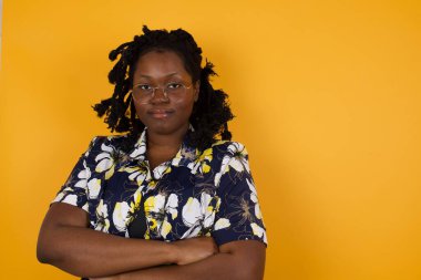 Güzel, kendine güvenen, neşeli, Afro-Amerikan kadınının belden yukarı vuruşu. Günlük kıyafetler giymiş, kolları çapraz, iş arkadaşıyla tanıştığı için mutlu.