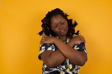 Hoş görünümlü, sevimli, çekici, çekici, etkileyici, bakımlı, hoş, sakin, barışçıl, Afro-Amerikan kadının portresi. Parlak arka planda kendini soyutluyor.