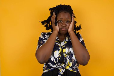 Güzel, Afro-Amerikan bir kadının portresi. Günlük giysiler içinde. Mutsuz bir ifadeyle el ele tutuşmuş..