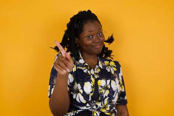 Woman gesturing a no sign. Closeup portrait unhappy, serious girl raising finger up saying: oh no you did not do that. Standing over yellow background. Negative emotions facial expressions, feelings.