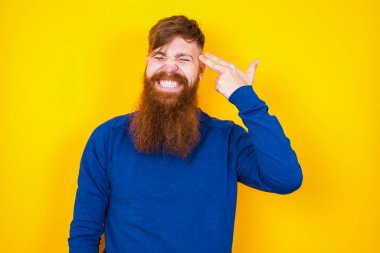 Mutsuz, yakışıklı, kızıl sakallı, beyaz adam sarı duvara dayanıyor. Silah sesi taklidi yapıyor. İntihar hareketi yapıyor..