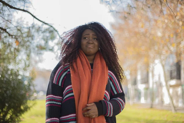 young beautiful African American woman wearing colorful sweater is felling offended in autumn  park