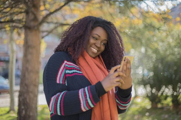 Νεαρή Όμορφη Αφροαμερικανή Γυναίκα Φορώντας Πουλόβερ Και Μαντήλι Χρησιμοποιώντας Smartphone — Φωτογραφία Αρχείου