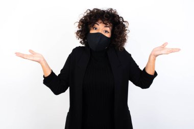 Belki evet ya da hayır. Kafkasyalı şüpheli bir kadın tıbbi maske takıyor şaşkınlıkla omuz silkiyor, ne istediğine karar vermeye çalışıyor. Tereddüt ve belirsizlik.