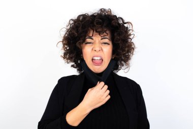 Vücut dili. Tıbbi maske takan, gergin, beyaz bir kadın kaşlarını çatmış, bir şeyden tiksindiğini gösteriyor..