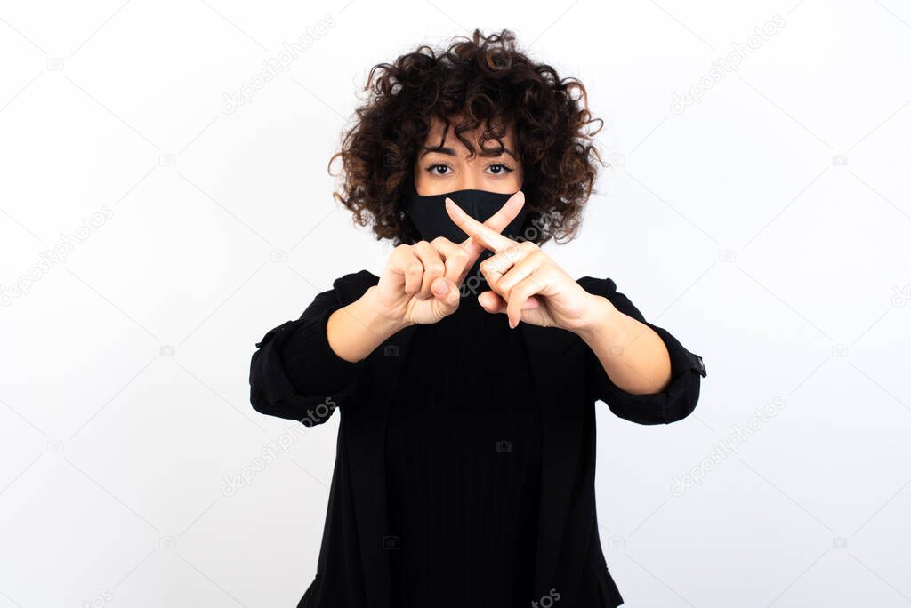  caucasian woman wearing medical mask has rejection angry expression crossing fingers doing negative sign.