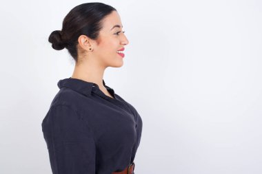 Sağlıklı ciltli, gülümseyen genç Latin kadın profili. Düşünceli bir ifadesi var. Açık havada yürümeye hazır..