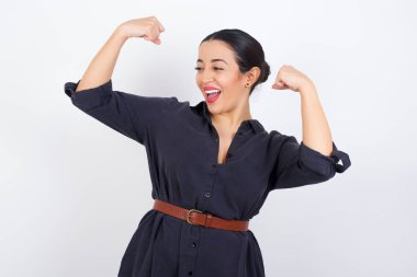 Evet, ben kazandım. Çekici, keyifli ve heyecanlı genç bir Latin kadının portresi. Elbise giymiş. Zaferle yumruklarını kaldırıyor..