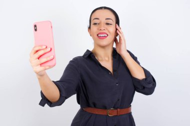 Arkadaşlarına ve takipçilerine göndermek ya da sosyal medyasına yüklemek için selfie çeken bir iş kadınının portresi.