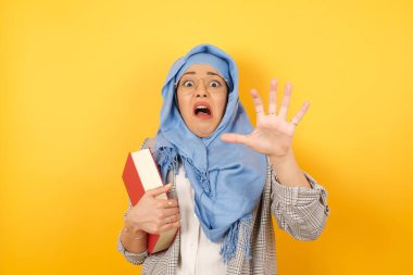 Tatmin olmamış, tesettürlü, tesettürlü genç Müslüman bir kadın. Kaşlarını çatmış, iğrenç bir ifade takınıyor. Dilini gösteriyor. İnsanlar ve olumsuz yüz ifadeleri