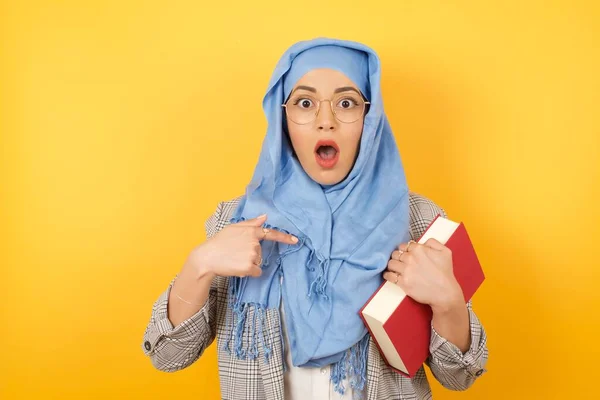 Έκπληκτη Όμορφη Νεαρή Μουσουλμάνα Γυναίκα Φορώντας Μαντίλα Κρατώντας Βιβλίο Κατάσταση — Φωτογραφία Αρχείου