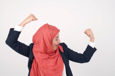 Evet, ben kazandım. Zevkli ve heyecanlı Müslüman kadın portresi zafer ve zaferle yumruklarını kaldırıyor zaferle gülümsüyor zevkten sırıtıyor..