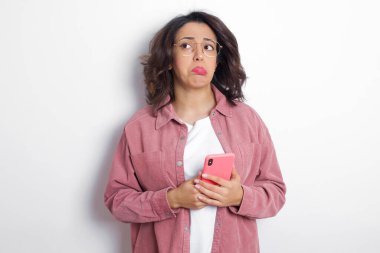 Tatmin olmamış esmer Arap kadın pembe gömlekli çanta dudaklı ve mutsuz bakışları var. Bunalımlı model.