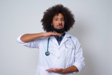 Genç ve güzel Afrikalı doktor üniformalı, elleri büyük ve büyük boy işareti gösteren, ölçü sembolü olan bir adam. Kameraya bakıp gülümsüyor. Ölçüm konsepti.