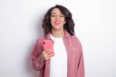 Esmer, Arap bir kadın pembe gömlek giyiyor ve gülümsüyor. Pozitif duygu kavramı