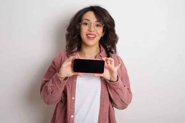 Junge Schöne Frau Zeigt Smartphone Studio Araberin Mit Brille Und — Stockfoto