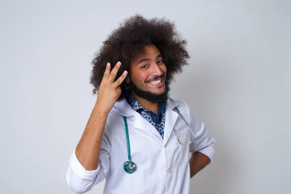 Молодой Доктор Медицинской Форме Стоящий Серой Стены Показывающий Пальцами Номер — стоковое фото