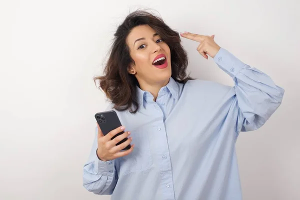 Schöne Geschäftsfrau Trägt Blaues Hemd Über Weißer Wand Mit Smartphone — Stockfoto