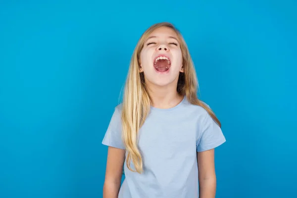 パニックで青いTシャツを着てストレスの多い美しい白人少女は 恐怖の中で目を閉じて 頭の上に手を置き 恐ろしいニュースを見つけます 信じられない — ストック写真