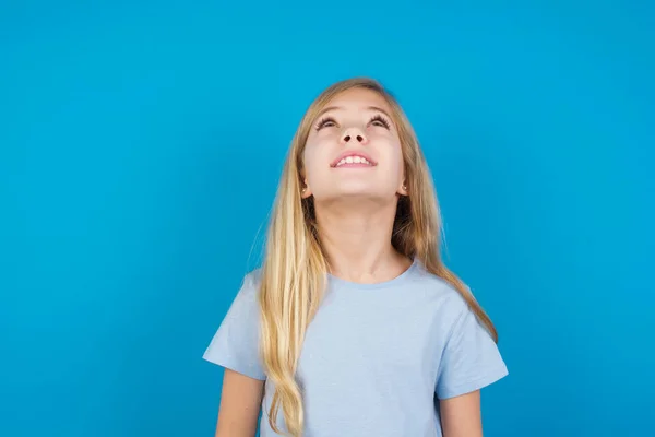 Hermosa Chica Caucásica Vistiendo Camiseta Azul Mirando Hacia Arriba Como —  Fotos de Stock