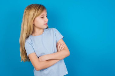 Kollarını kavuşturmuş tişört giyen üzgün, beyaz bir kız resmi. Kötü haberleri dinledikten sonra hayal kırıklığına uğramış bir ifadeyle bakıyorum..