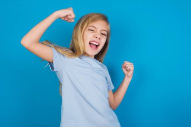 Evet, ben kazandım. Çekici, keyifli ve heyecanlı beyaz kız portresi tişört giymiş zafer ve zaferle yumruklarını kaldıran keyifle sırıtan zafer gülümsemesi.