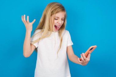 Öfkeden kudurmuş, tişört giyen güzel beyaz kızın fotoğrafı cep telefonu tutuyor, telefon ediyor, iş arkadaşıyla tartışıyor, olumsuz duygularını ifade ediyor. İnsanlar ve öfke.