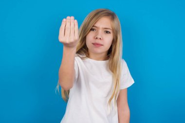 Güzel beyaz kız tişört giyiyor. İtalyan jesti yapıyor. Elleri ve parmakları kendinden emin ifade ediyor.