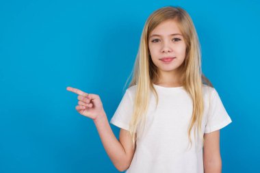  Beyaz tişört giyen güzel beyaz kız boş alanda yan yana duran reklamları gösteriyor. Halk ve tanıtım konsepti